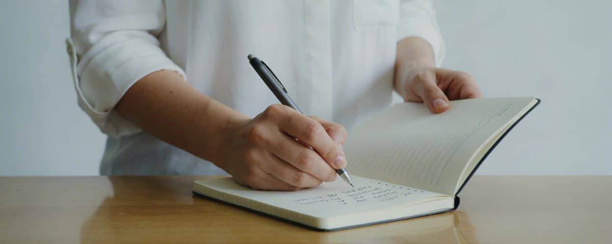 aide soignante en blouse note des salaires sur tableau