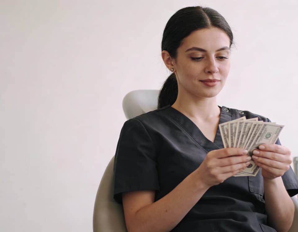 Assistante dentaire assise comptant des billets