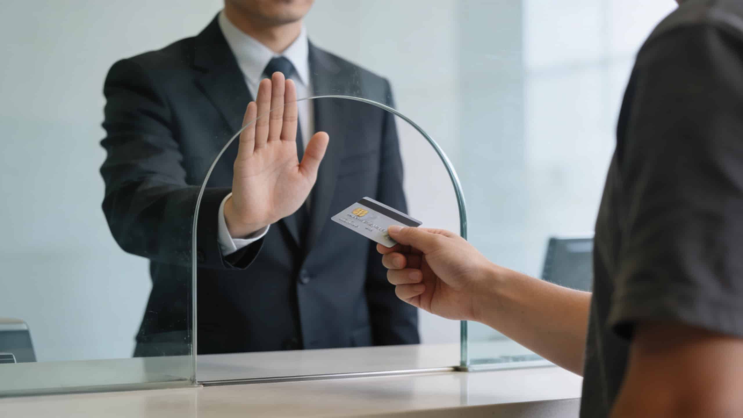 guichetier refuse virement client montrant carte bancaire