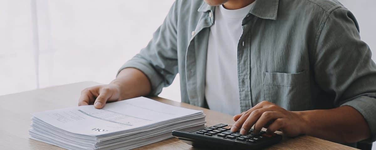 homme assis au bureau calculant interets de pret