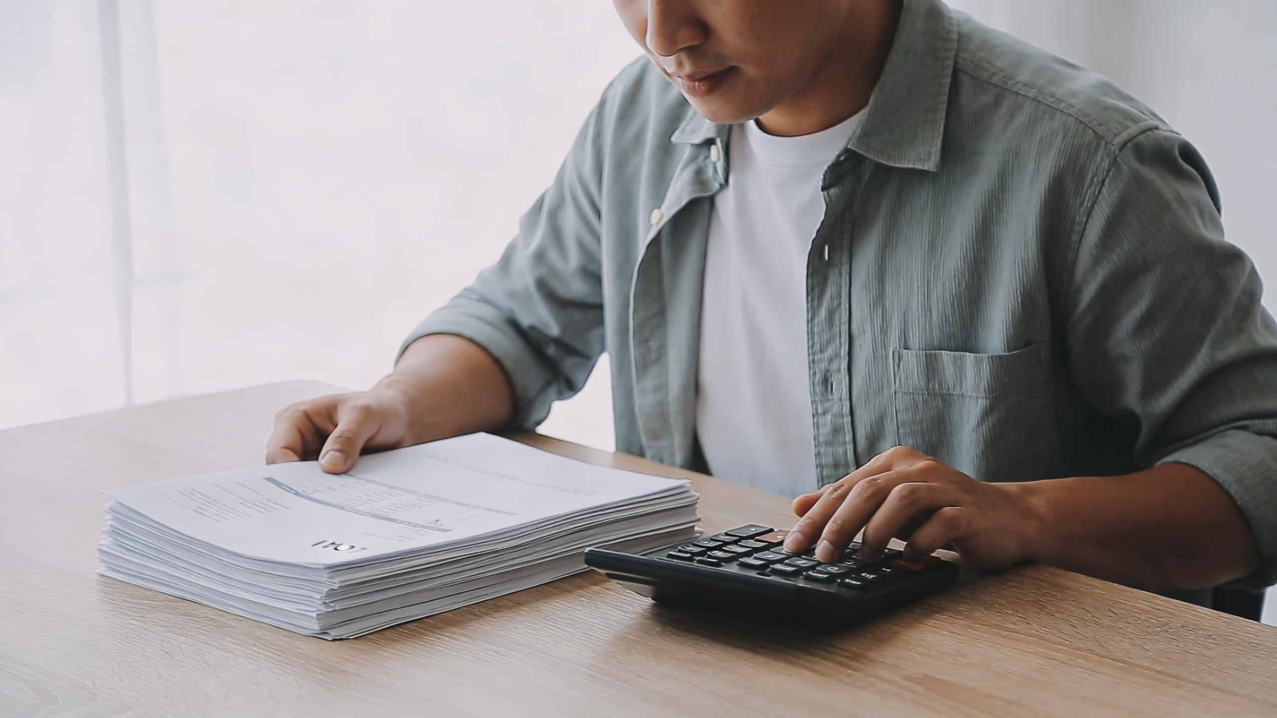 homme assis au bureau calculant interets de pret