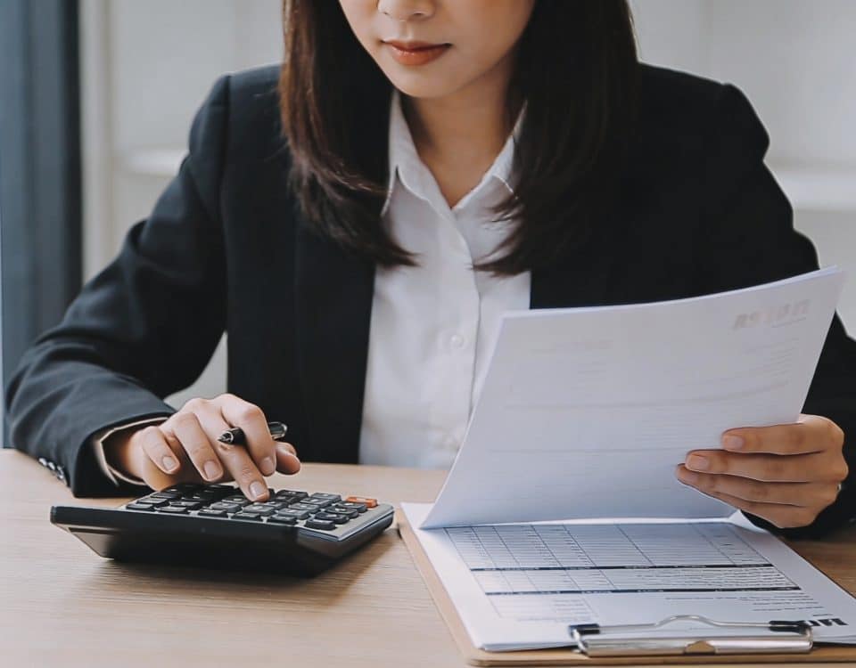 jeune agent immobilier assis au bureau calculatrice et fiches de paie