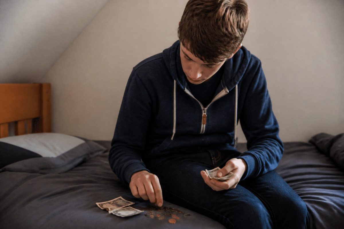 Adolescent comptant des billets et des pieces de monnaie
