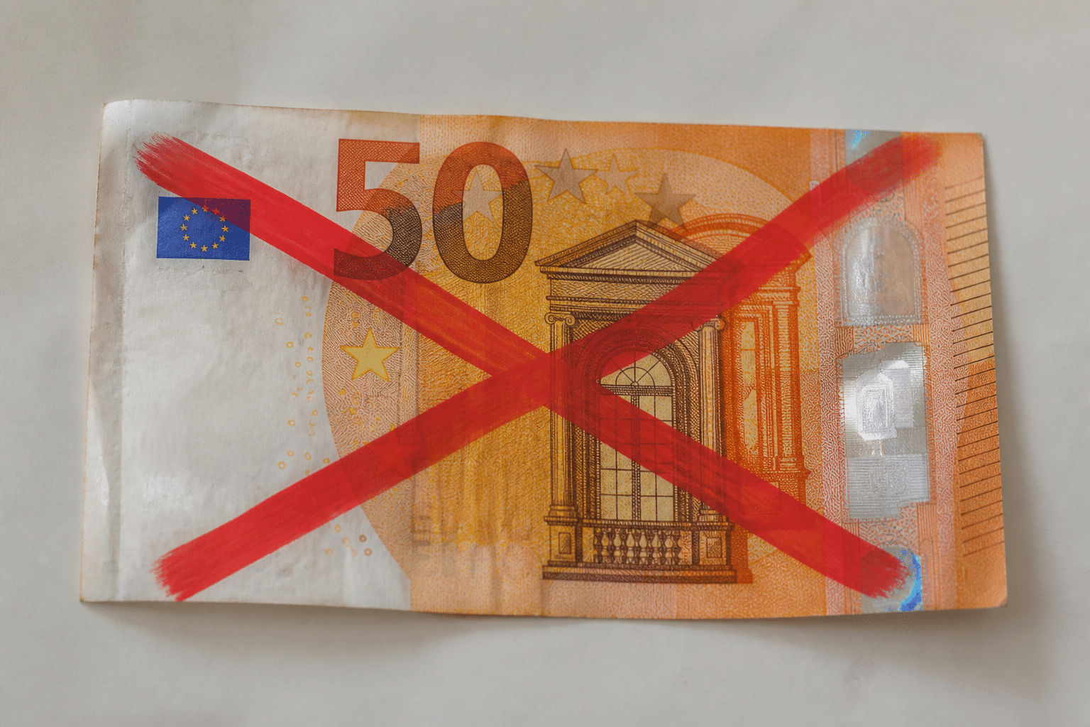 Billet de cinquante euros barré d'une croix rouge interdite.