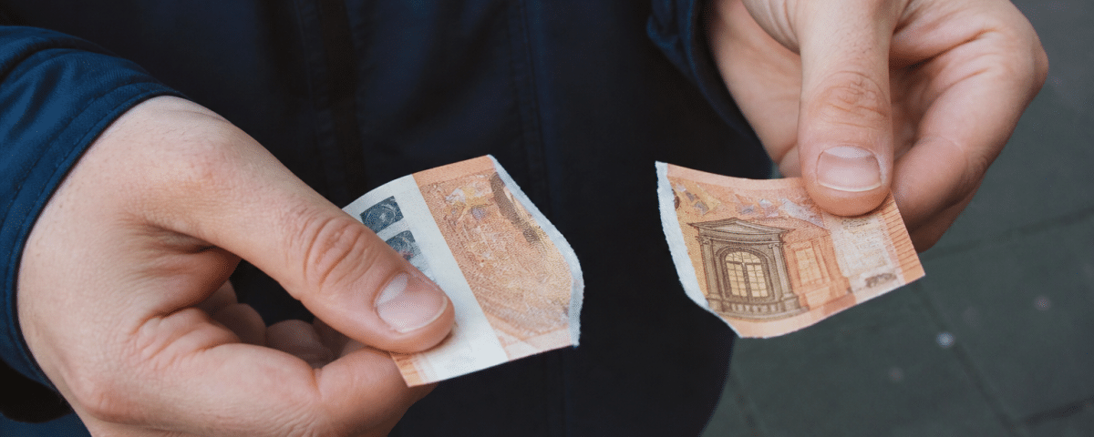 Billet de cinquante euros dechire en deux morceaux.