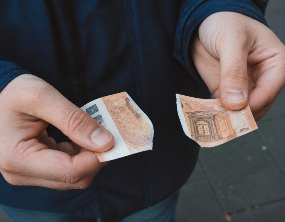 Billet de cinquante euros dechire en deux morceaux.