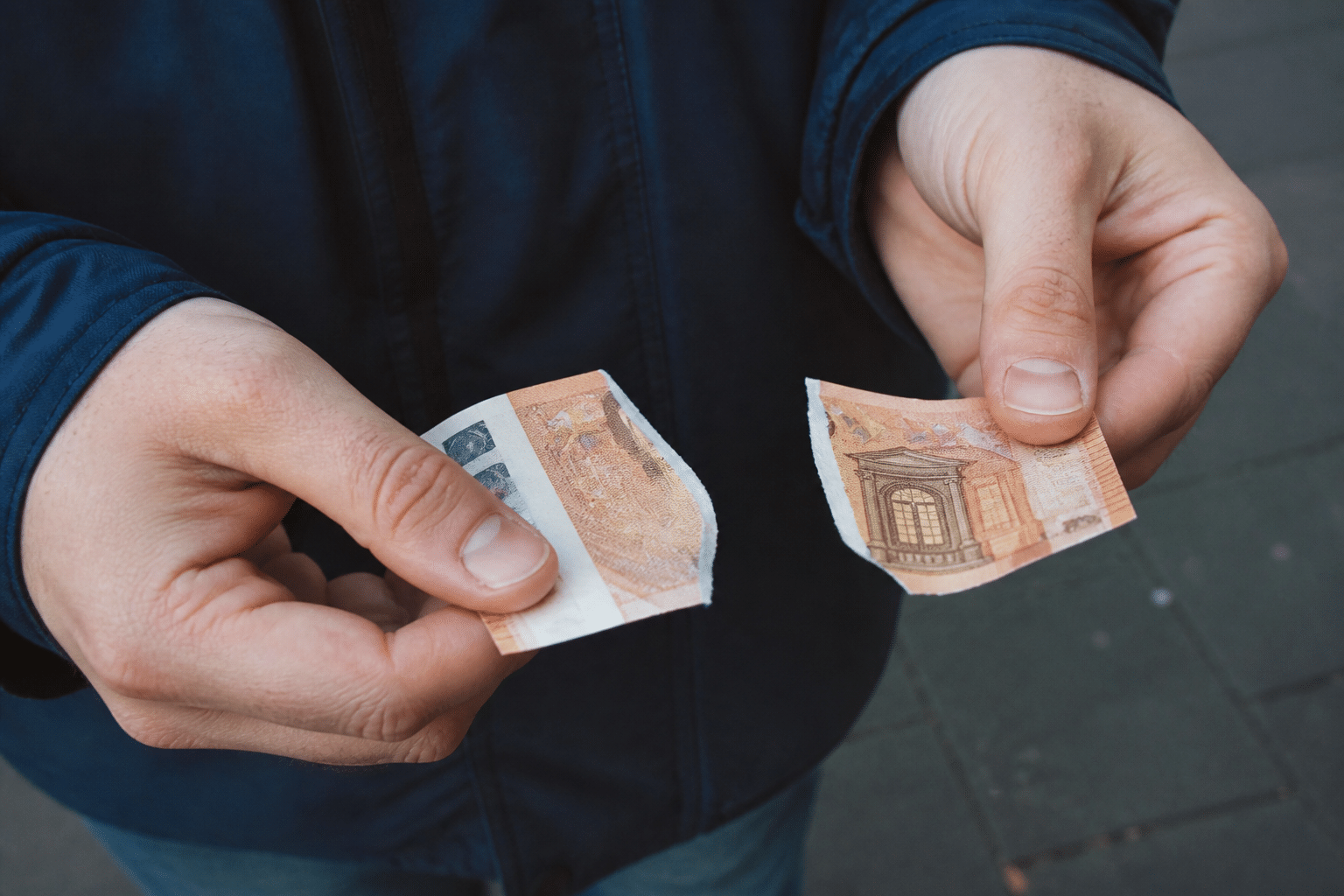 Billet de cinquante euros dechire en deux morceaux.