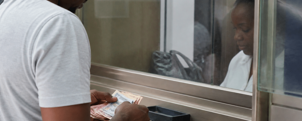 Client comptant billets et pieces au guichet bancaire.