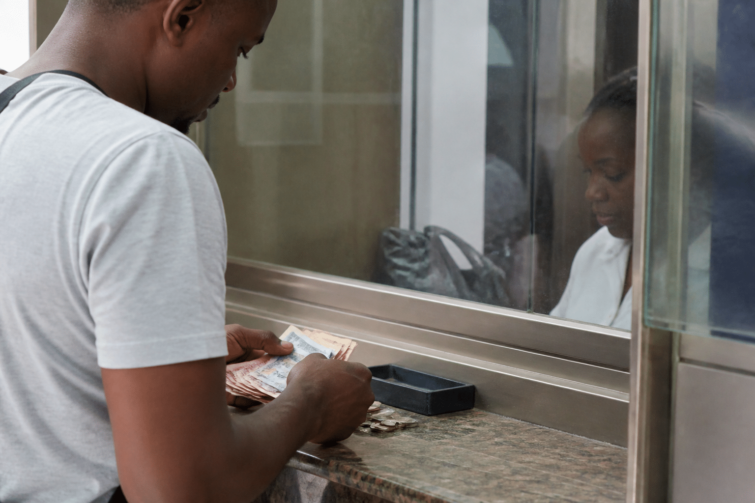Client comptant billets et pieces au guichet bancaire.