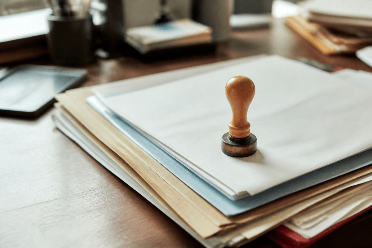 Dossiers administratifs avec documents officiels et timbre notarial.