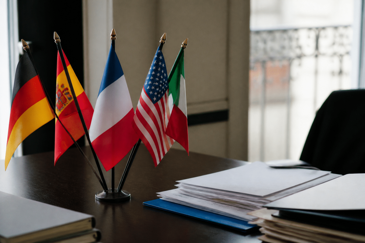 Plusieurs drapeaux nationaux sur bureau avec documents salariaux.