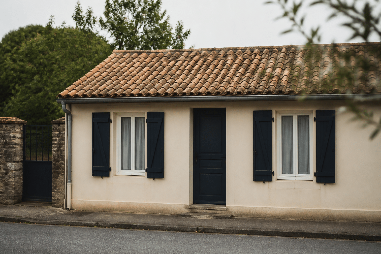 Facade d'une petite maison basse sans etages visibles.