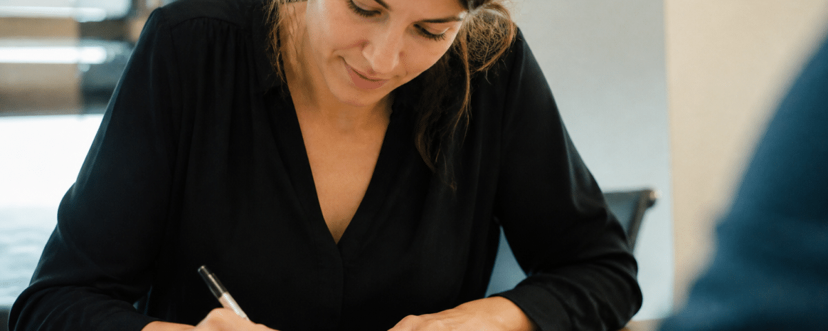 Femme assise signant contrat emploi permanent bureau