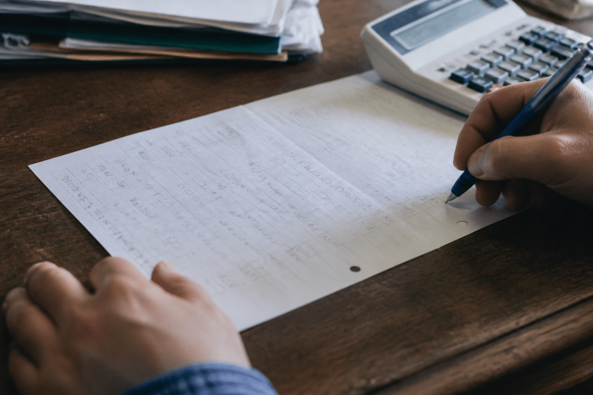 Feuille de papier avec calculs et chiffres financiers visibles