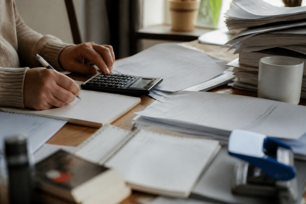 Formulaire administratif avec calculs financiers et documents officiels empiles.
