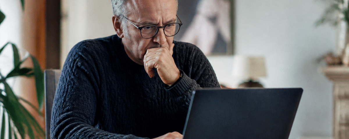 Homme age assis devant ordinateur consultant offres emploi.