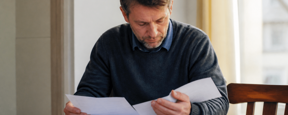 Homme consultant documents administratifs sur table de travail