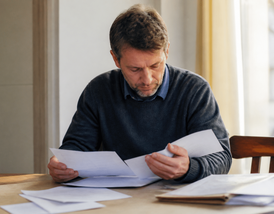 Homme consultant documents administratifs sur table de travail