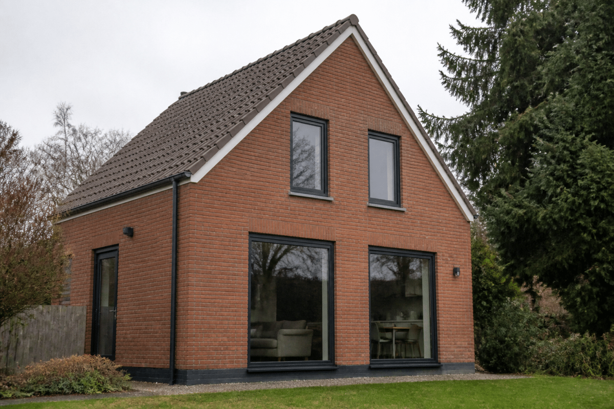 Maison brique avec toit deux pans et grandes fenêtres