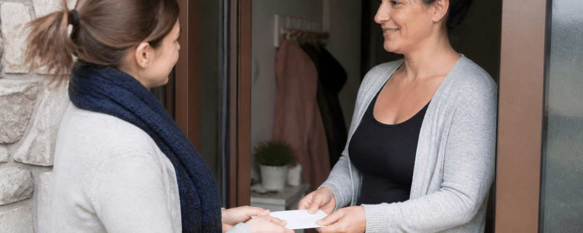 Parent remettant enveloppe argent à gardienne enfants