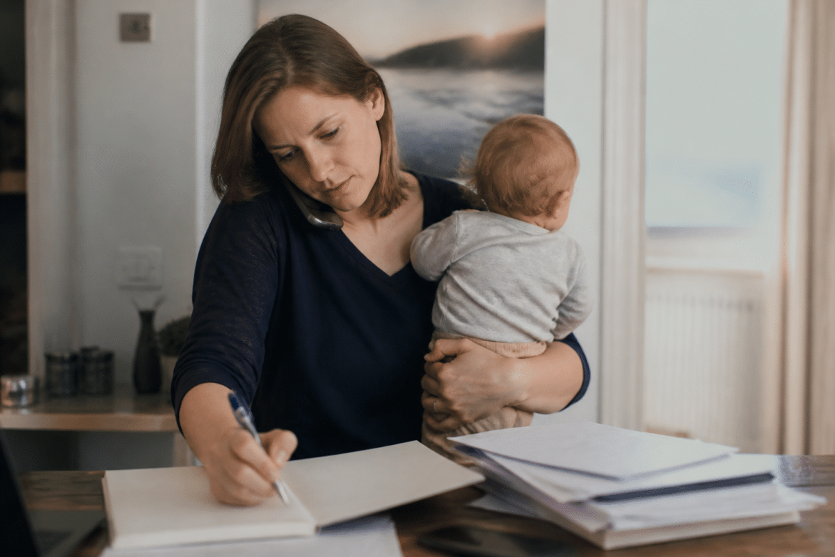 Personne jonglant agenda, documents professionnels et bénévolat simultanément.