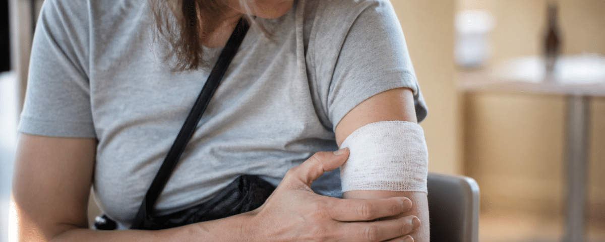 Personne assise tenant son bras immobilise apres injection.