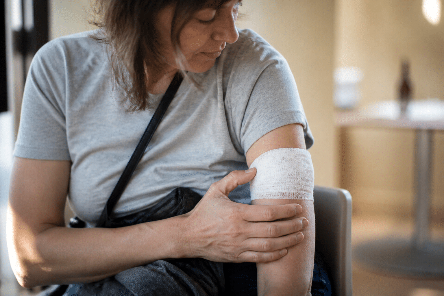 Personne assise tenant son bras immobilise apres injection.
