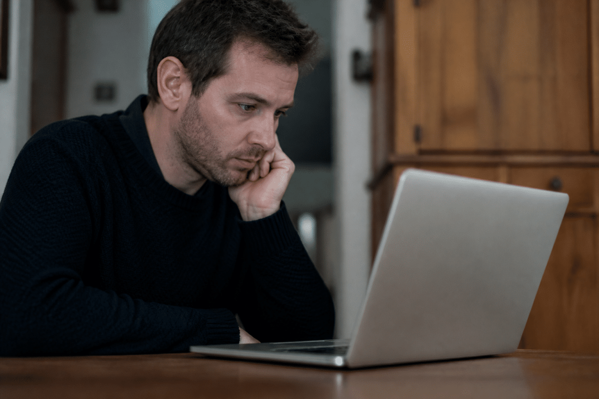 Personne consultant son compte bancaire sur ordinateur portable.