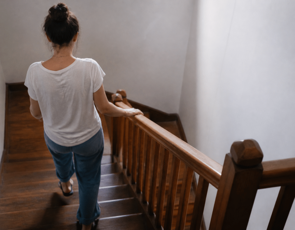 Personne descendant escalier en bois avec rampe