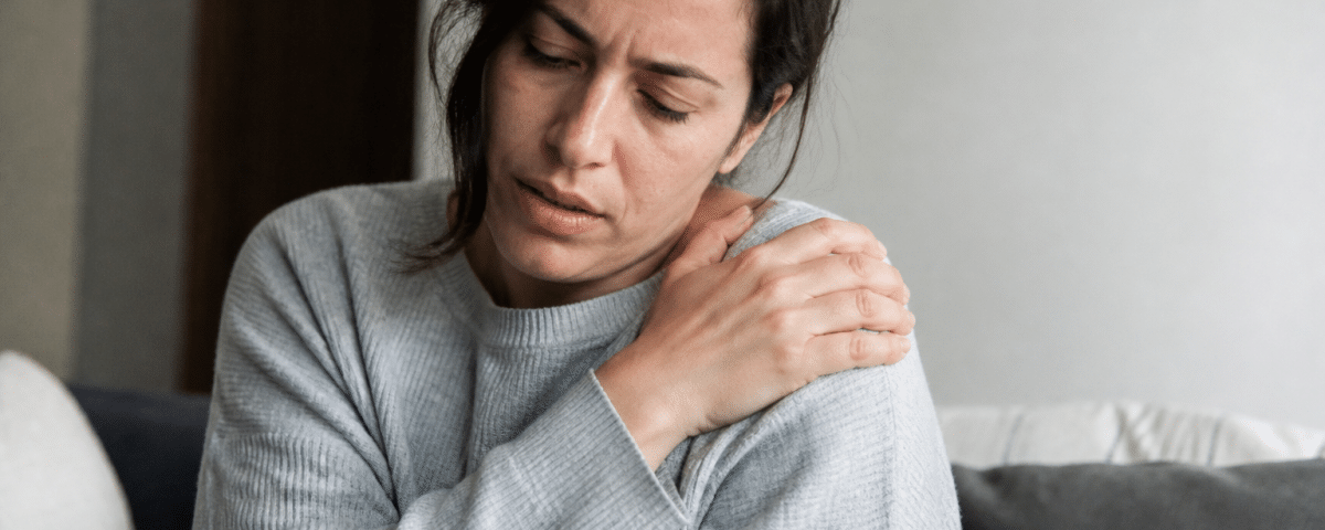 Personne tenant son epaule douloureuse avec sa main