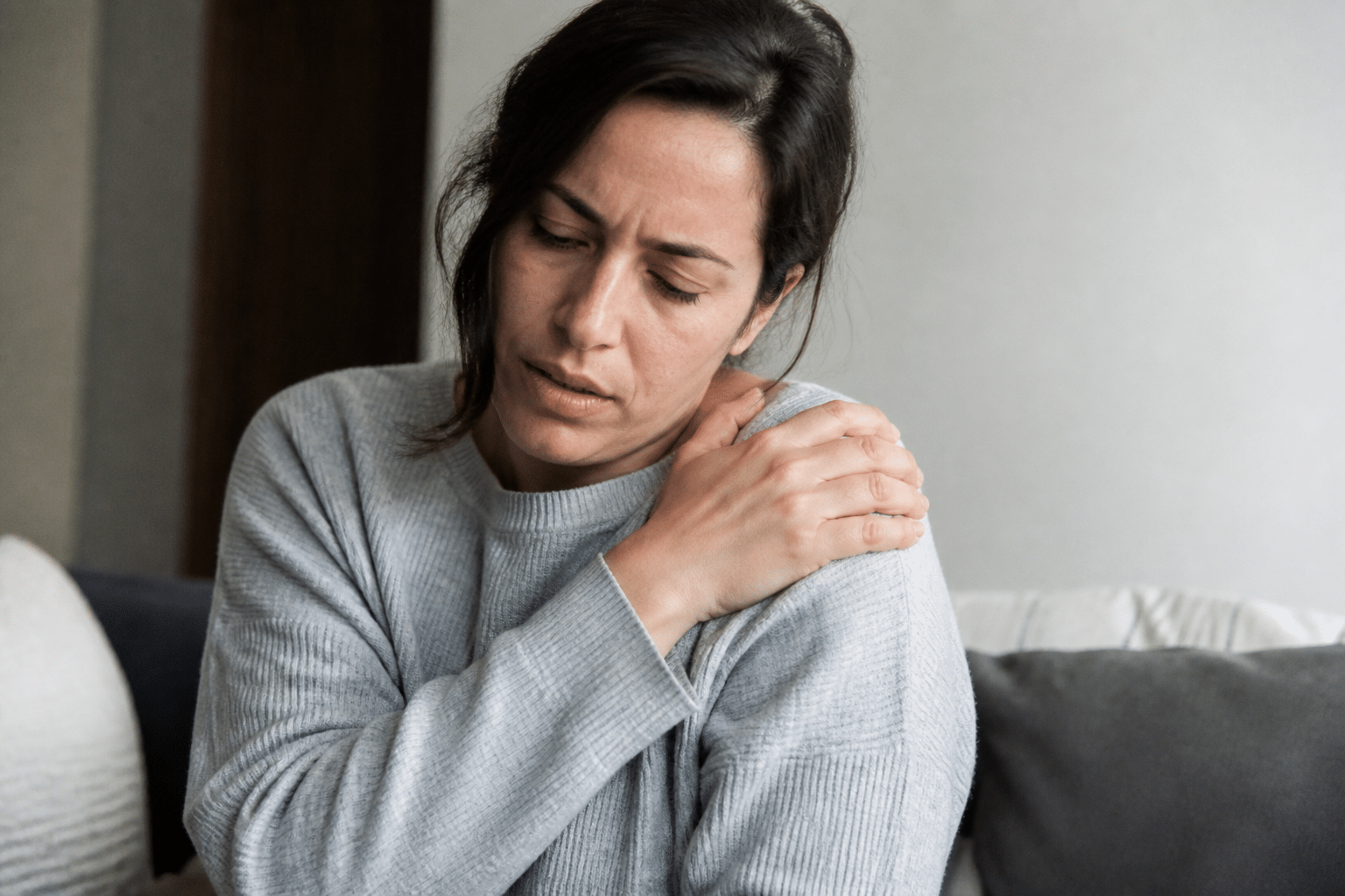 Personne tenant son epaule douloureuse avec sa main