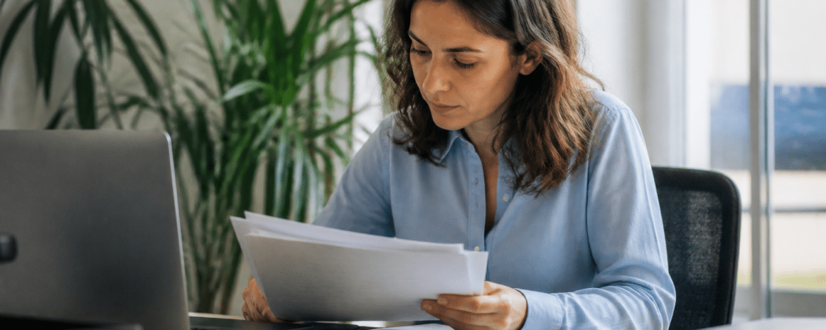 Personne etudiant des documents professionnels a son bureau