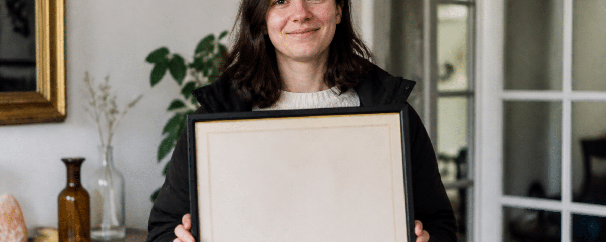 Personne tenant un diplôme encadré devant elle
