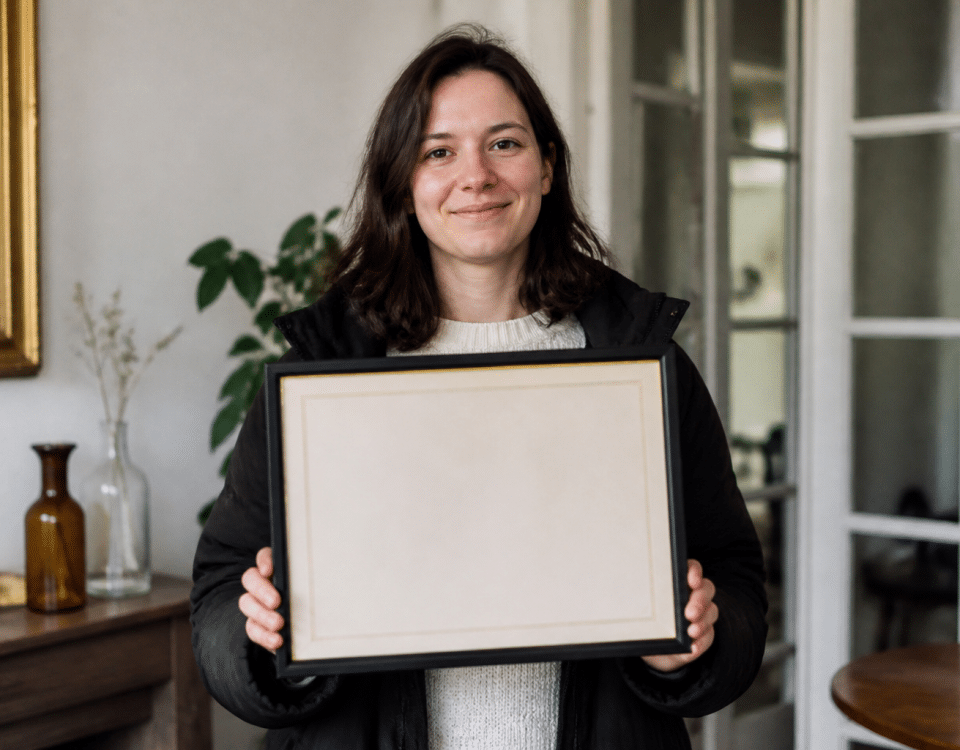 Personne tenant un diplôme encadré devant elle