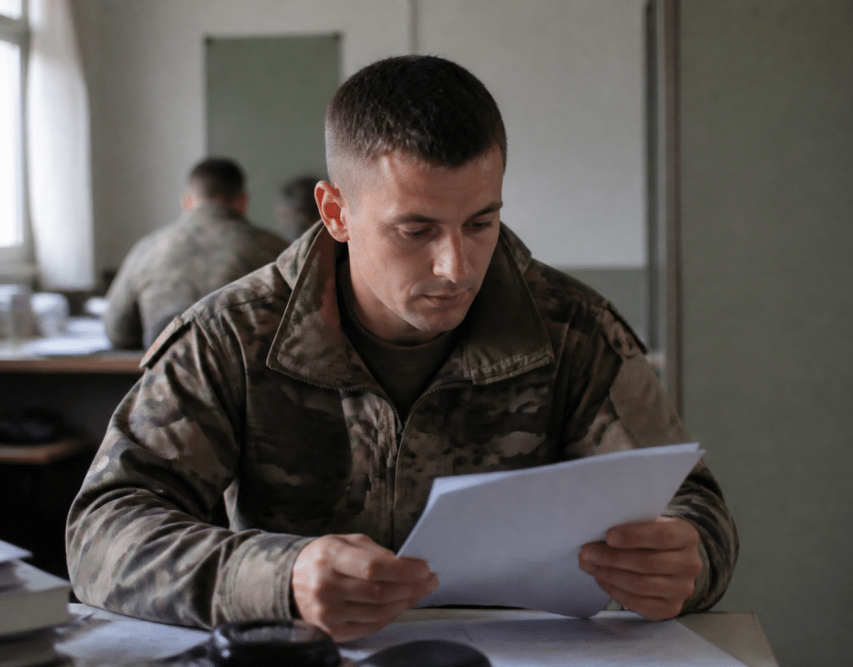 Soldat en uniforme consulte document militaire assis bureau.